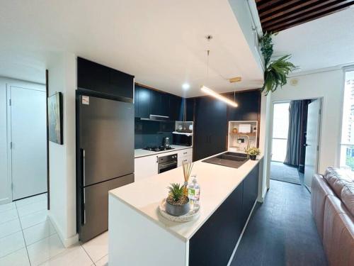 a kitchen with a refrigerator and a counter top at S&P Apartments - Festival in Brisbane
