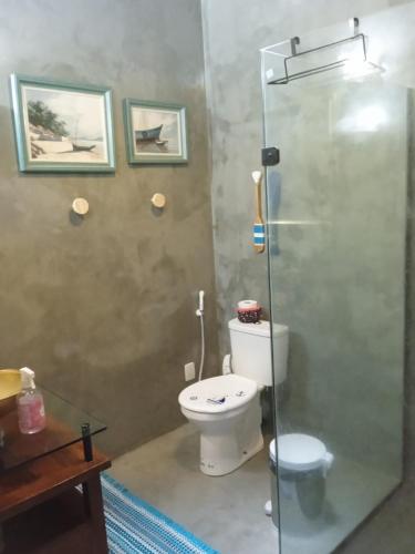 a bathroom with a toilet and a glass shower at QUINTAS DA BARRA BNB a 30m da praia in Balneario Barra do Sul