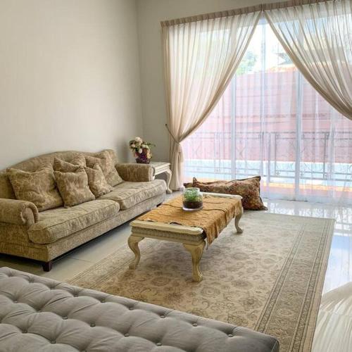 uma sala de estar com um sofá e uma mesa de centro em Santai Homestay Jb em Johor Bahru