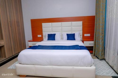 a bedroom with a large white bed with blue pillows at Luxe Furnished Premium Unit in Meru