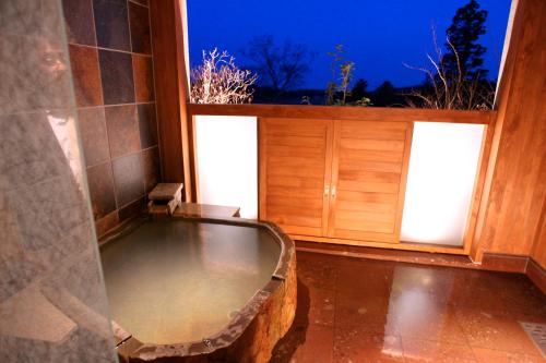 a bath tub in a room with a window at Wellness Forest Nasu in Nasu