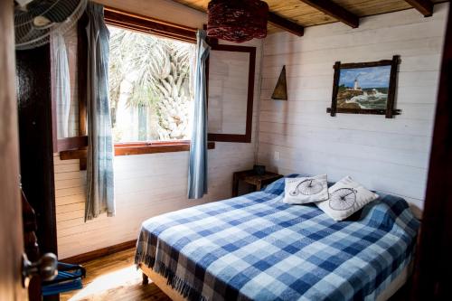 Un dormitorio con una cama azul y blanca con una ventana en Abuela Ana, en Aguas Dulces