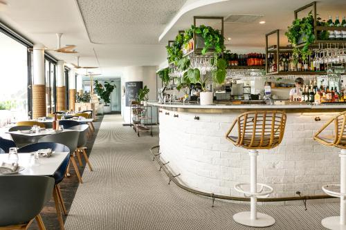 莫里莫科Bannisters Pavilion Mollymook的一间带桌子的用餐室和一间酒吧