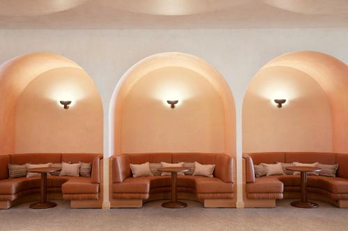 a restaurant with two arches with couches and tables at Manly Pacific Sydney MGallery Collection in Sydney