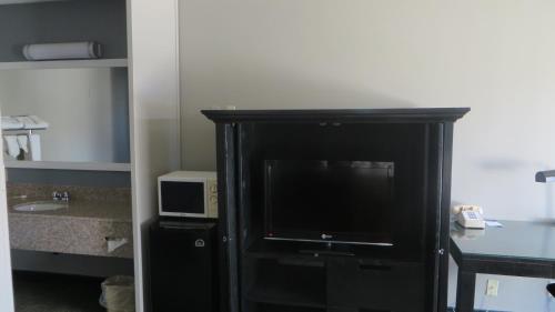 a black cabinet with a television in a room at Hotel Salina Beaumont CA in Beaumont