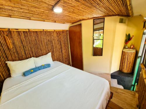 1 dormitorio con 1 cama blanca en una habitación en Hospedaje Combi dream bird en Guanacaste