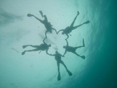 a group of people forming a heart in the water at Adang Sea Divers & Eco Lodge in Ko Lipe