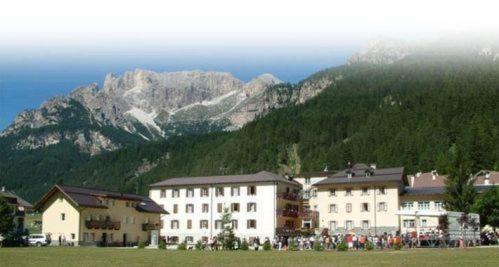 um grupo de edifícios em frente a uma montanha em Soggiorno Dolomiti em Mazzin