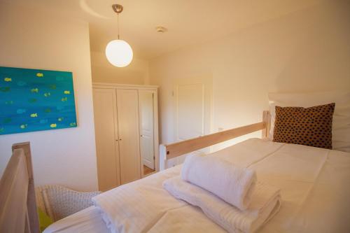 a bedroom with a bed with white towels on it at Greetsieler Inselhuus - Südwind in Greetsiel