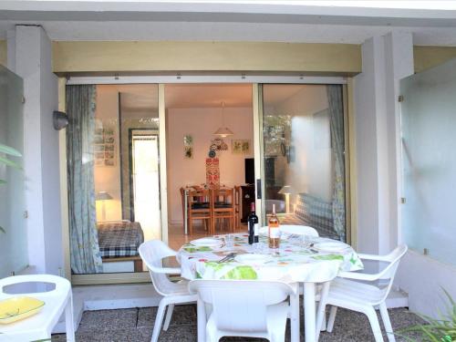 une table blanche et des chaises sur une terrasse dans l'établissement Appartement 3P en RDJ avec Jardin, accès plage direct, 4 à 6 couchages - Villeneuve-Loubet Plage - FR-1-252A-73, à Villeneuve-Loubet
