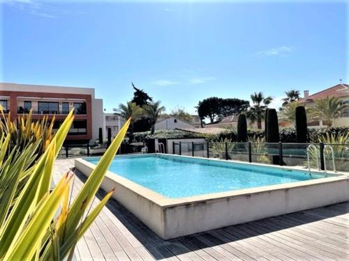 - une piscine au milieu d'un patio orné de plantes dans l'établissement Appartement Climatisé 3P, Piscine, Terrasse Sud, Parking Privé, Proche Plage et Gare - FR-1-252A-70, à Villeneuve-Loubet