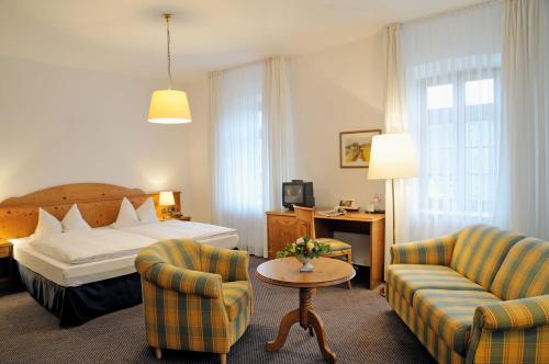 a hotel room with a bed and two chairs at Landhotel Donner in Meschede