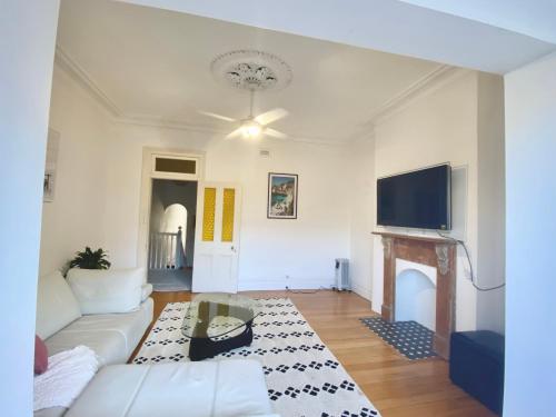 a living room with a couch and a tv at Sunny Apartment in Surry Hills in Sydney