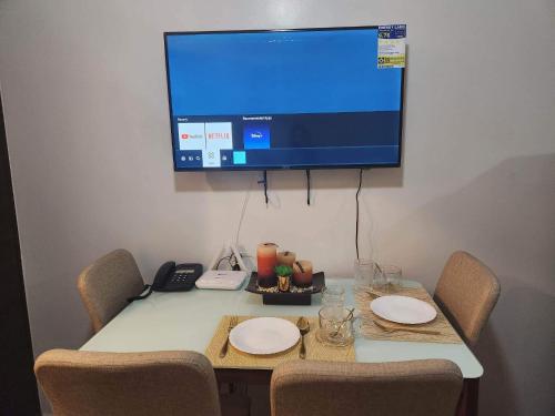 a table with two chairs and a television on a wall at air residences in Manila