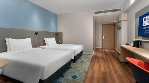 a hotel room with two beds and a tv at Holiday Inn Express Shunde Daliang by IHG in Shunde