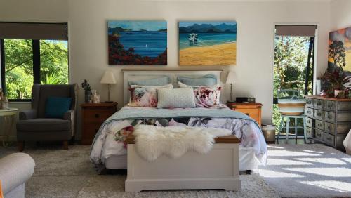 a bedroom with a bed and a painting on the wall at Boutique Art Retreat in Upper Hutt