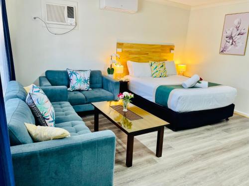 a hotel room with a bed and a couch at Highway Motor Inn Taree in Taree