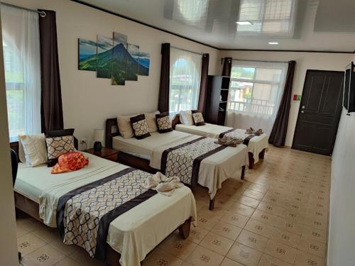 a hotel room with four beds in a room at HOTEL DEL RiO in Liberia