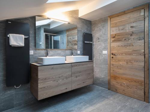 a bathroom with two sinks and a wooden door at Appartement Duplex 94m² Courchevel Village - Pour 6 personnes - Pieds des pistes avec Parking et Wifi - FR-1-631-111 in Courchevel