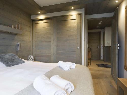 une chambre avec un lit avec des serviettes dessus dans l'établissement Courchevel Moriond: Appartement 42m², 4 pers, proche pistes avec WIFI et parking - FR-1-631-115, à Courchevel