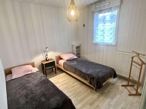 2 Betten in einem Zimmer mit Fenster in der Unterkunft Appartement Étel, 3 pièces, 4 personnes - FR-1-479-144 in Étel