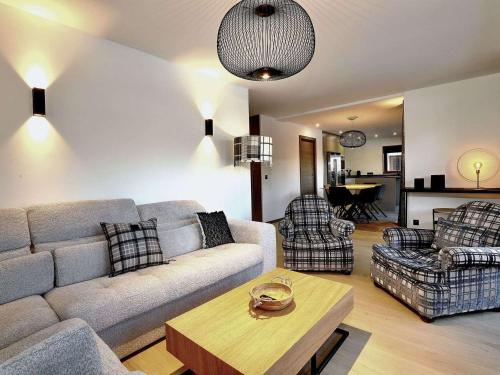 un salon avec un canapé, des chaises et une table dans l'établissement Appartement neuf et spacieux proche des pistes à Courchevel Le Praz - FR-1-568-32, à Courchevel