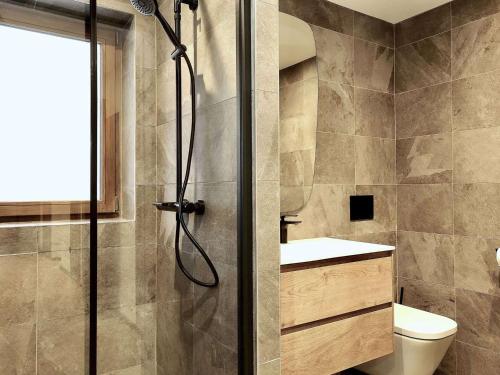 une salle de bain avec douche et toilettes dans l'établissement Appartement neuf et spacieux proche des pistes à Courchevel Le Praz - FR-1-568-32, à Courchevel