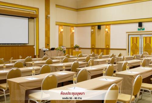 a classroom with tables and chairs and a projection screen at Asia Airport Hotel in Bangkok