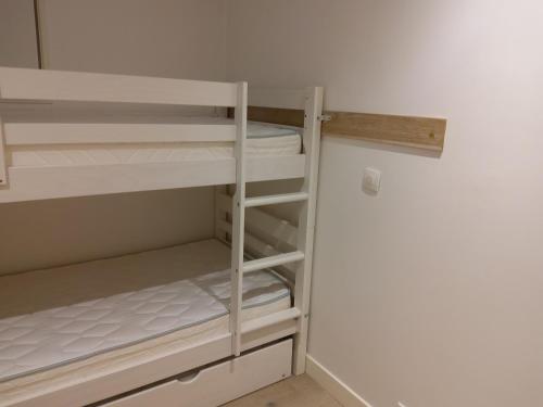 Cette chambre comprend un placard avec des lits superposés blancs. dans l'établissement Charmant 2 pièces au centre de Méribel avec balcon et WiFi - FR-1-411-872, à Les Allues