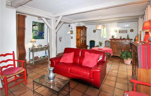 un salon avec un canapé rouge et une table dans l'établissement Lovely Home In Cheval-Blanc, à Cheval-Blanc