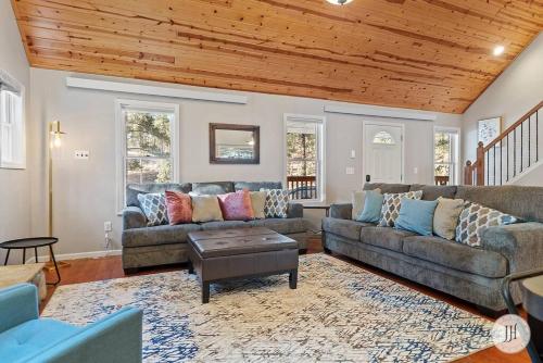 a living room with two couches and a wooden ceiling at Elk Ridge Fire Place Custer in Custer