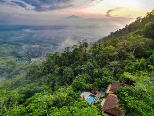 a view of a mountain with a house in the forest at Villa Borobudur Resort in Borobudur