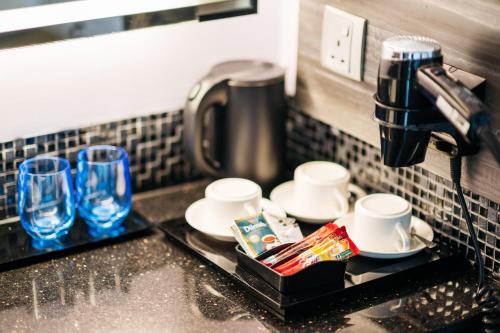 a kitchen sink with cups and a coffee maker at Mercure Singapore Tyrwhitt in Singapore