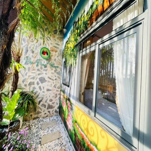 a side of a building with a window and flowers at Pine Forest House Dalat in Xuan An