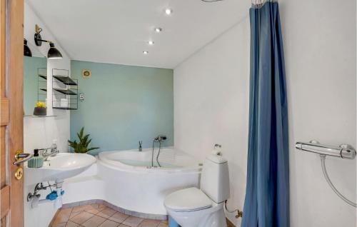 y baño con bañera, aseo y lavamanos. en 1 Bedroom Awesome Apartment In Hjer en Højer