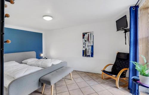 Højer的住宿－1 Bedroom Awesome Apartment In Hjer，一间卧室配有一张床、一台电视和一把椅子