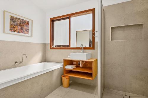 a bathroom with a tub and a sink and a shower at Philippas Paddock in Cowes