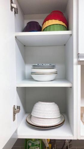 a white cabinet with plates and bowls and a hat at DDUBLE Square in Daegu