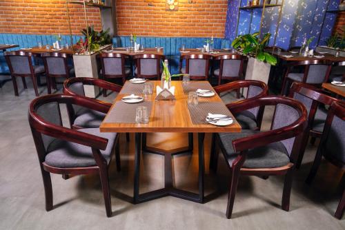 a dining room with a wooden table and chairs at Lantern Apart Hotel in Perintalmanna
