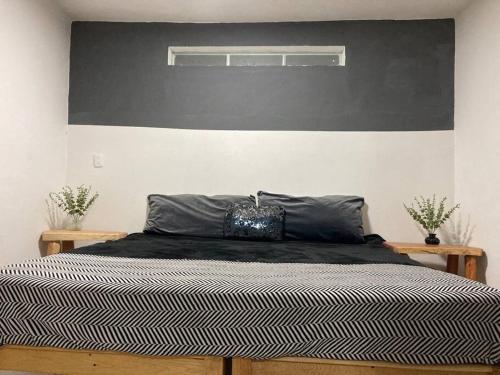 1 dormitorio con 1 cama grande y cabecero negro en Depa wifi en corredor de balnearios, en Ixmiquilpan