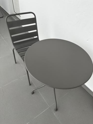 a white table and a chair in a room at Pomme Surette in Sainte-Anne