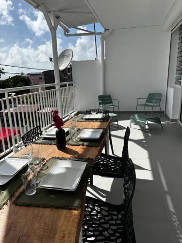 a wooden table and chairs on a balcony at Pomme Surette in Sainte-Anne