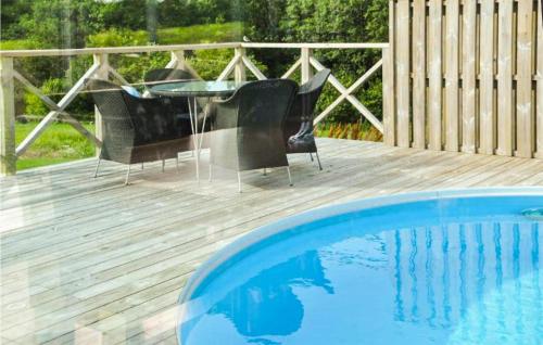 a deck with a table and chairs next to a pool at Pet Friendly Home In Laholm With Wifi in Laholm