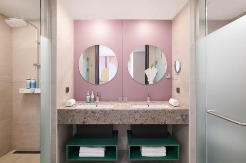 een badkamer met 2 wastafels en 2 spiegels bij ibis Styles Ambassador Incheon Airport T2 in Incheon