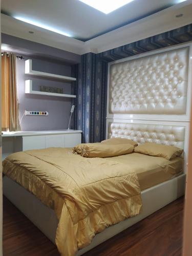a bedroom with a large bed with a white headboard at Apartemen Green Palace View Kalibata in Jakarta