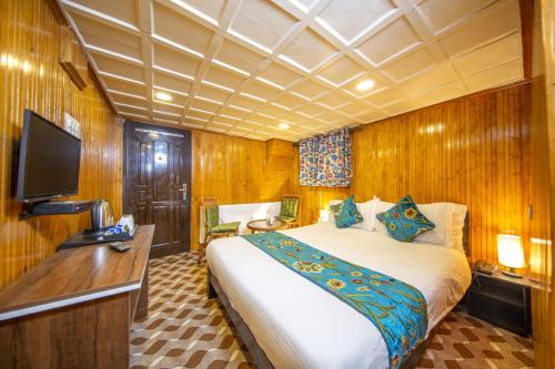 a bedroom with a bed and a desk and a tv at Gulmarg Ski Hill Resort in Gulmarg