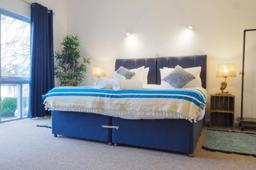 a bedroom with a blue bed with white pillows at Coverack in Budock Water