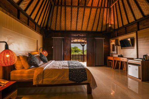 um quarto com uma cama num quarto com uma cozinha em The Kleep Jungle Resort em Nusa Penida