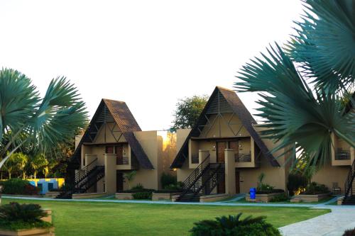 a building with palm trees in front of it at Jagira Ananta Elite , Sasan Gir in Chitrod