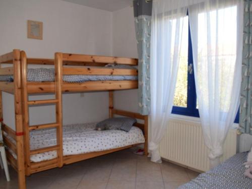 une chambre avec deux lits superposés et une fenêtre dans l'établissement Maison près de la plage avec jardin clos, terrasse et plancha - 5 couchages - FR-1-224B-121, à La Guérinière